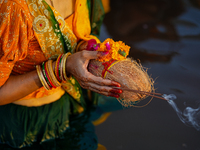 Hindu devotees perform rituals and offer prayers at sunset on the banks of the River Sabarmati during the Chhath Puja festival in Ahmedabad,...