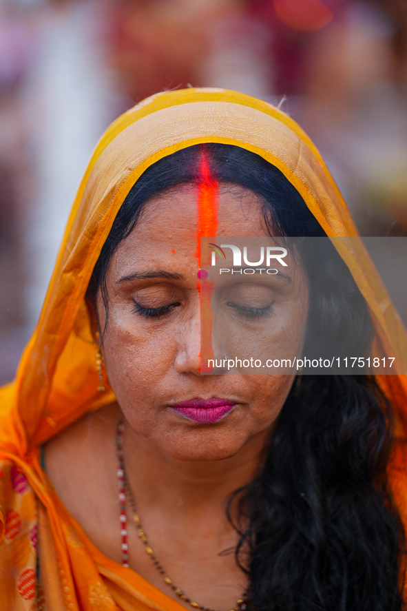 Hindu devotees perform rituals and offer prayers at sunset on the banks of the River Sabarmati during the Chhath Puja festival in Ahmedabad,...