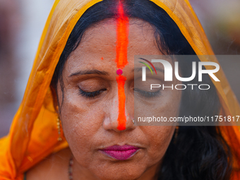 Hindu devotees perform rituals and offer prayers at sunset on the banks of the River Sabarmati during the Chhath Puja festival in Ahmedabad,...