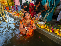 Hindu devotees perform rituals and offer prayers at sunset on the banks of the River Sabarmati during the Chhath Puja festival in Ahmedabad,...