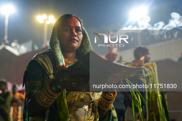 Hindu devotees perform rituals and offer prayers at sunset on the banks of the River Sabarmati during the Chhath Puja festival in Ahmedabad,...