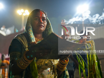 Hindu devotees perform rituals and offer prayers at sunset on the banks of the River Sabarmati during the Chhath Puja festival in Ahmedabad,...