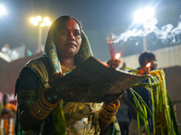 Hindu devotees perform rituals and offer prayers at sunset on the banks of the River Sabarmati during the Chhath Puja festival in Ahmedabad,...