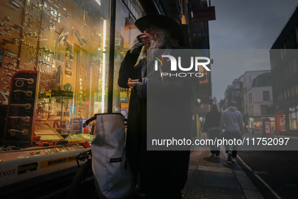 A man stands outside a shop in Soho, on October 5, 2024. 