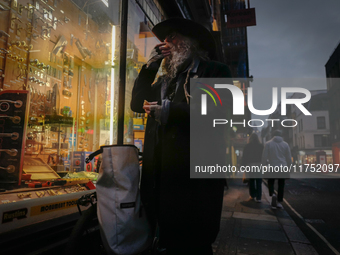 A man stands outside a shop in Soho, on October 5, 2024. (