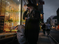 A man stands outside a shop in Soho, on October 5, 2024. (