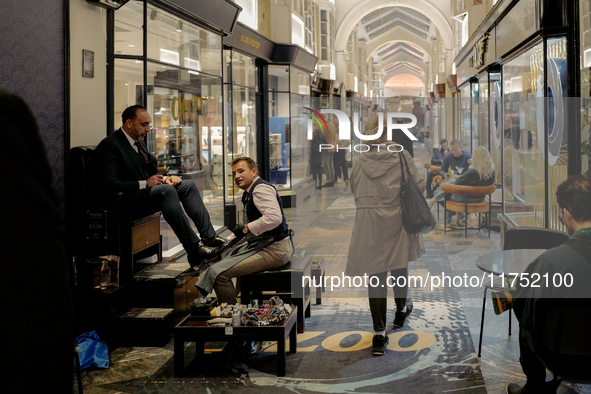 A shoe shiner works in the Burlington Arcade in London, England, on November 5, 2024. 