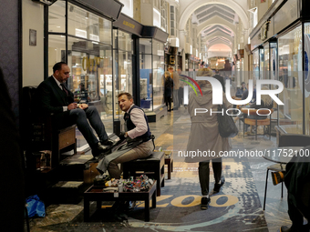 A shoe shiner works in the Burlington Arcade in London, England, on November 5, 2024. (