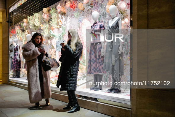 People stand outside a shop in Mayfair, London, on November 7, 2024. 