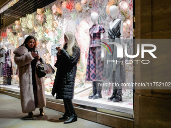 People stand outside a shop in Mayfair, London, on November 7, 2024. (