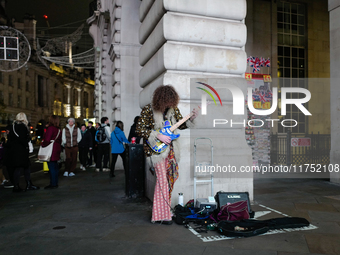 A street musician plays a guitar in Piccadilly Circus, London, on November 7, 2024. (