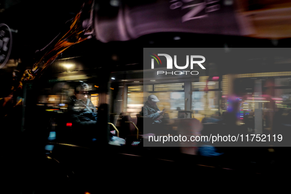 A man sits on a bus as it drives on Regent Street in London, United Kingdom, on November 7, 2024. 