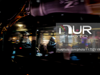 A man sits on a bus as it drives on Regent Street in London, United Kingdom, on November 7, 2024. (