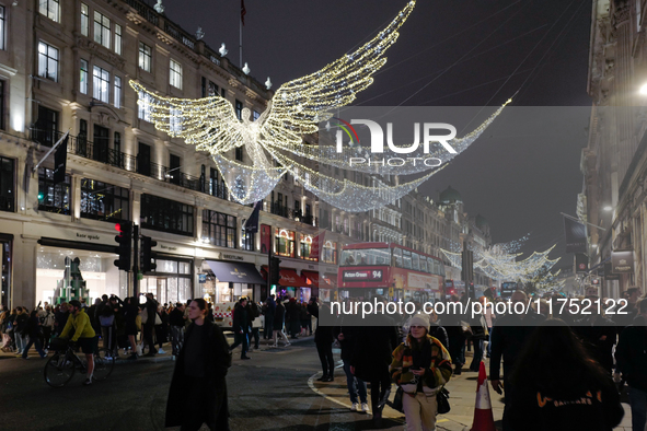 People gather and take photos of the Christmas lights in Regent Street, London, on November 7, 2024. 