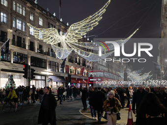 People gather and take photos of the Christmas lights in Regent Street, London, on November 7, 2024. (