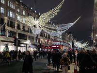 People gather and take photos of the Christmas lights in Regent Street, London, on November 7, 2024. (