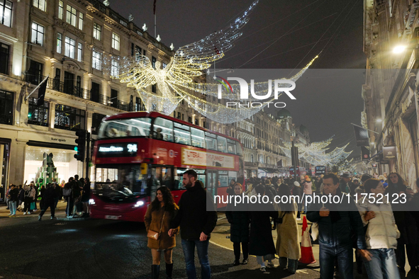 People gather and take photos of the Christmas lights in Regent Street, London, on November 7, 2024. 