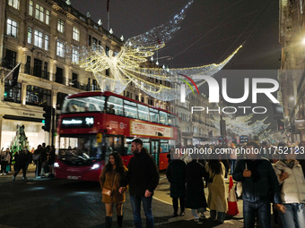 People gather and take photos of the Christmas lights in Regent Street, London, on November 7, 2024. (