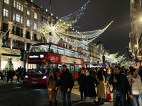 People gather and take photos of the Christmas lights in Regent Street, London, on November 7, 2024. (