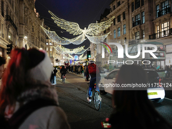 People take photos of the Christmas lights in Regent Street, London, on November 7, 2024. (