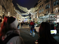 People take photos of the Christmas lights in Regent Street, London, on November 7, 2024. (