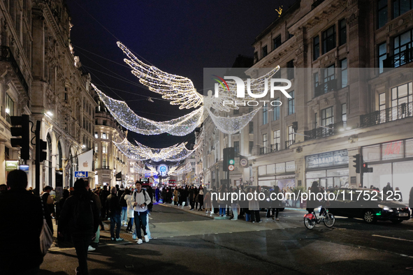 People take photos of the Christmas lights in Regent Street, London, on November 7, 2024. 