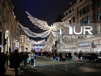 People take photos of the Christmas lights in Regent Street, London, on November 7, 2024. (