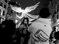 People take photos of the Christmas lights in Regent Street, London, on November 7, 2024. (