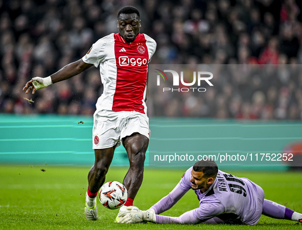 AFC Ajax Amsterdam forward Brian Brobbey and Maccabi Tel Aviv goalkeeper Roi Mishpati play during the match between Ajax and Maccabi Tel Avi...