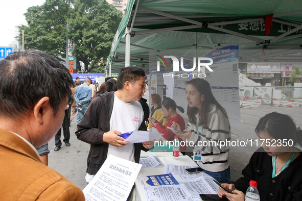 Job seekers learn about employment at a job fair in Chongqing, China, on November 7, 2024. 