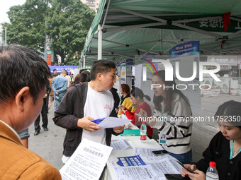 Job seekers learn about employment at a job fair in Chongqing, China, on November 7, 2024. (