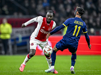 AFC Ajax Amsterdam forward Bertrand Traore and Maccabi Tel Aviv midfielder Sagiv Jehezkel play during the match between Ajax and Maccabi Tel...