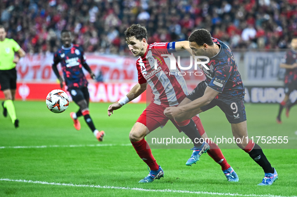 Panagiotis Retsos of Olympiacos FC competes with Cyriel Dessers of Rangers during the Europa League, Matchday 4 match between Olympiacos FC...