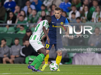 In Seville, Spain, on November 7, 2024, Ivan Brnic of NK Celje competes for the ball with Youssouf Sabaly of Real Betis during the UEFA Conf...