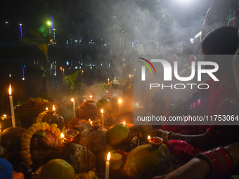 Hindu devotees prepare offerings as they worship the Sun God during the Hindu religious festival of Chhath Puja in Kolkata, India, on Novemb...