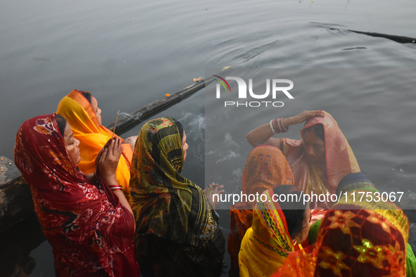 Hindu women worship the Sun god in the early morning during the religious festival of Chhath Puja at a pond in Kolkata, India, on November 8...