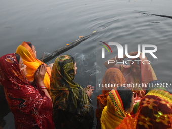 Hindu women worship the Sun god in the early morning during the religious festival of Chhath Puja at a pond in Kolkata, India, on November 8...