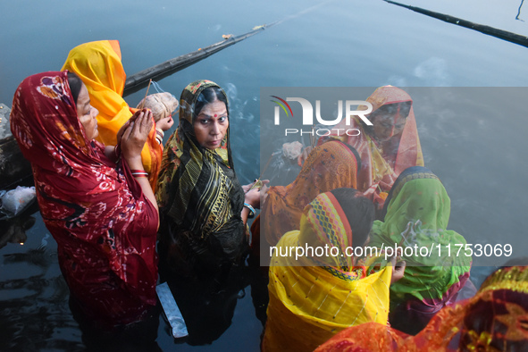 Hindu women worship the Sun god in the early morning during the religious festival of Chhath Puja at a pond in Kolkata, India, on November 8...