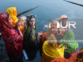 Hindu women worship the Sun god in the early morning during the religious festival of Chhath Puja at a pond in Kolkata, India, on November 8...