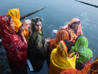 Hindu women worship the Sun god in the early morning during the religious festival of Chhath Puja at a pond in Kolkata, India, on November 8...