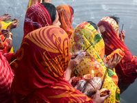 Hindu women worship the Sun god in the early morning during the religious festival of Chhath Puja at a pond in Kolkata, India, on November 8...