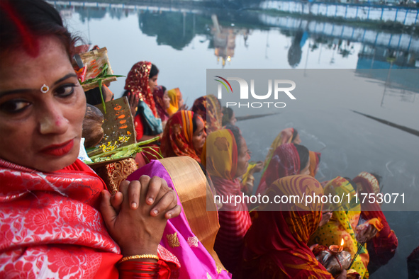 Hindu women worship the Sun god in the early morning during the religious festival of Chhath Puja at a pond in Kolkata, India, on November 8...