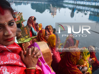 Hindu women worship the Sun god in the early morning during the religious festival of Chhath Puja at a pond in Kolkata, India, on November 8...