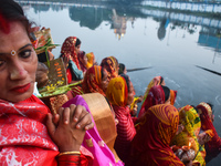 Hindu women worship the Sun god in the early morning during the religious festival of Chhath Puja at a pond in Kolkata, India, on November 8...