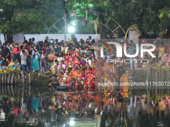 Hindu women worship the Sun god in the early morning during the religious festival of Chhath Puja at a pond in Kolkata, India, on November 8...