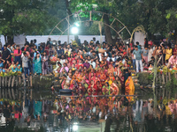 Hindu women worship the Sun god in the early morning during the religious festival of Chhath Puja at a pond in Kolkata, India, on November 8...