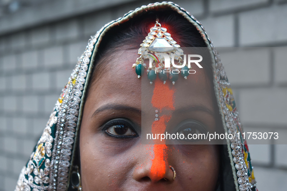 A Hindu woman with ''sindhur,'' or vermilion powder, on her forehead worships the sun god during the religious festival of Chhath Puja at a...