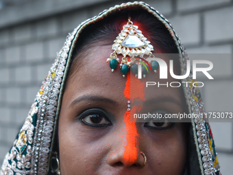 A Hindu woman with ''sindhur,'' or vermilion powder, on her forehead worships the sun god during the religious festival of Chhath Puja at a...