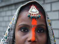 A Hindu woman with ''sindhur,'' or vermilion powder, on her forehead worships the sun god during the religious festival of Chhath Puja at a...