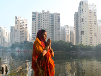 A Hindu woman worships the Sun god in the early morning during the religious festival of Chhath Puja at a pond in Kolkata, India, on Novembe...